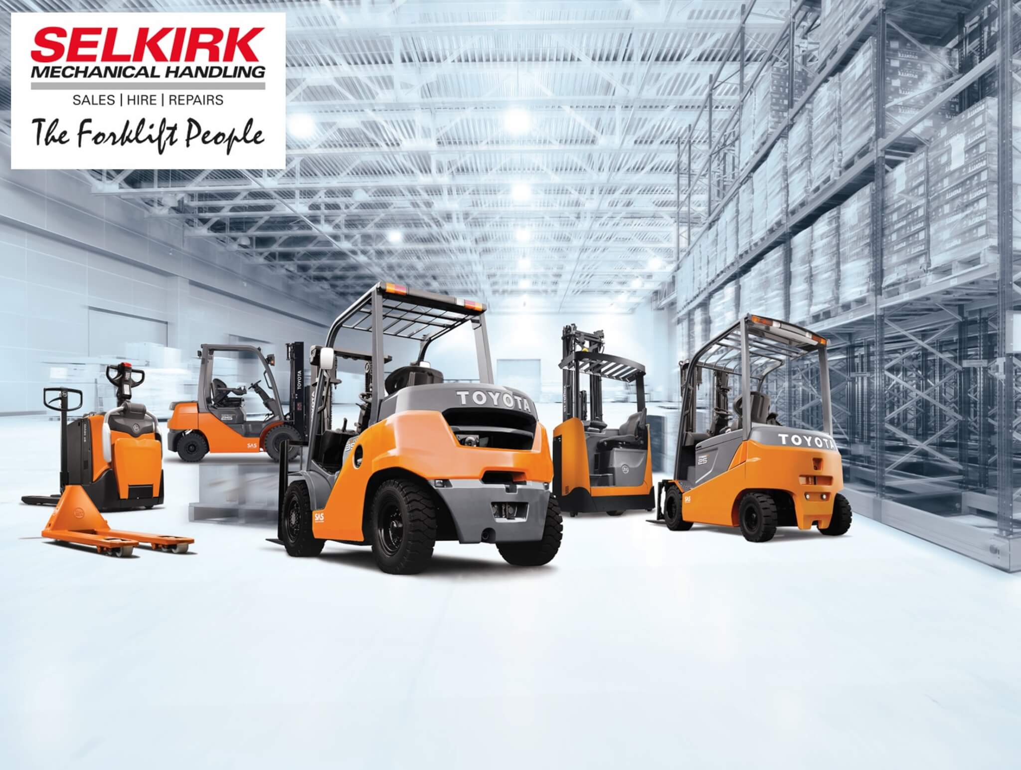 A number of orange and black mechanical handling machines parked in a white warehouse.