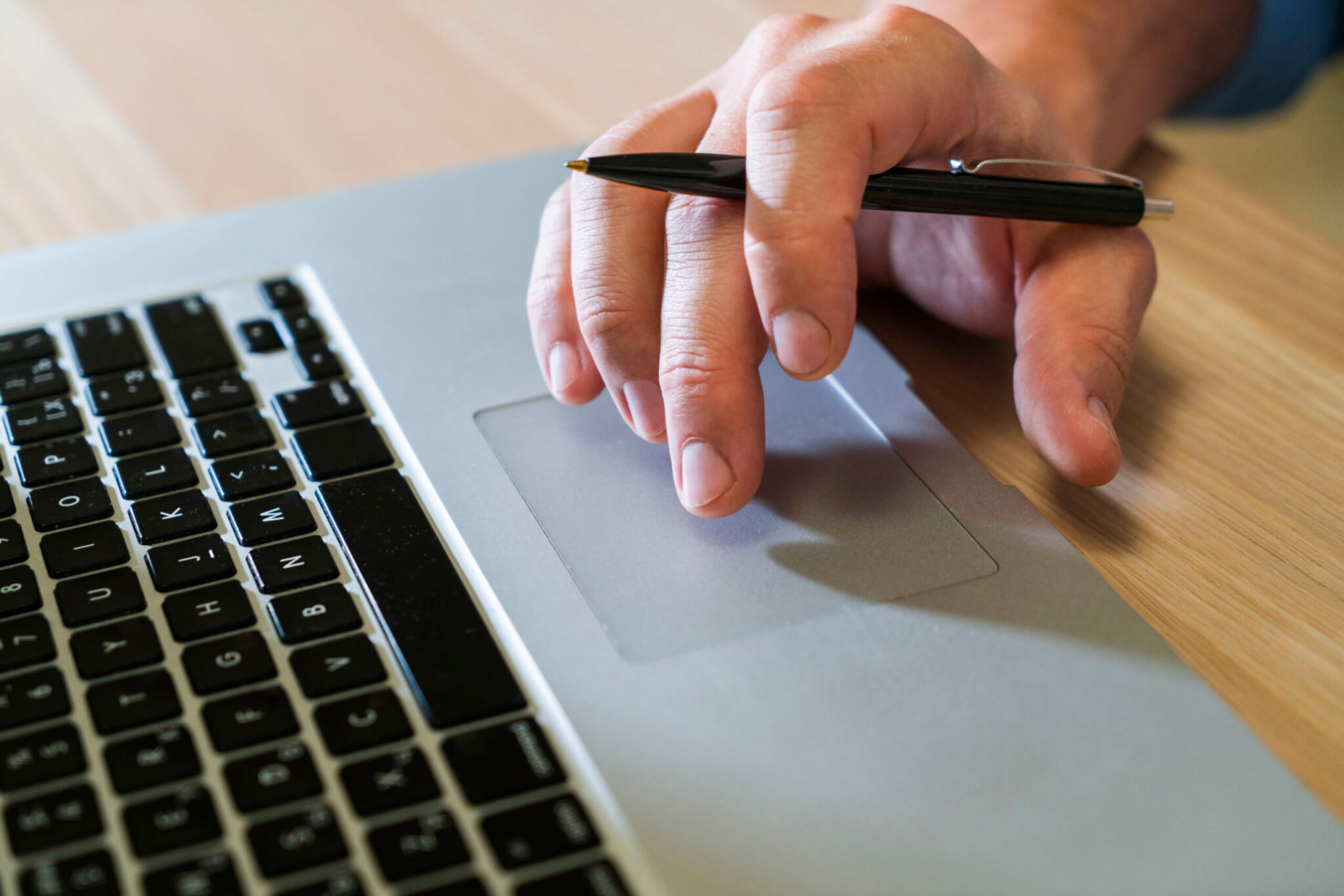 A close up of a hand using a trackpad on a laptop.